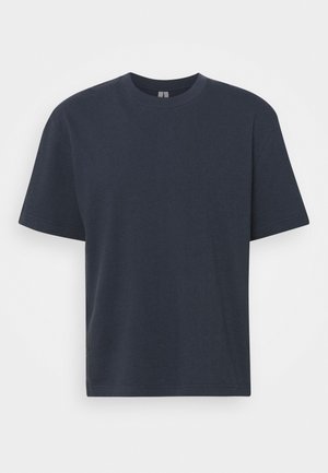 T-shirt en coton bleu marine avec col rond, manches courtes et coupe décontractée. Texture lisse avec une couleur unie et sans motifs visibles.