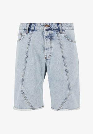 Heledad helesin sinised teksapüksid, millel on hargnenud serv, nurgelised õmblused ja klassikaline viie taskuga disain. Kulunud detailid vöökoha juures.