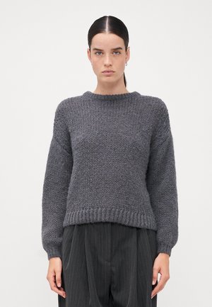 Grauer Strickpullover mit Rundhalsausschnitt, überschnittenen Schultern und geripptem Saum. Hergestellt aus einem strukturierten Garn, mit lockerer Passform und weichem Erscheinungsbild.