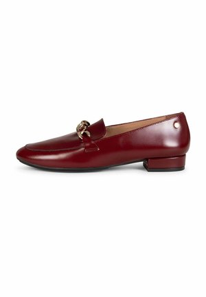 Mocasín de cuero rojo oscuro para mujer con tacón bajo de bloque y detalle de cadena en tono dorado en la parte superior, vista lateral sobre fondo blanco.