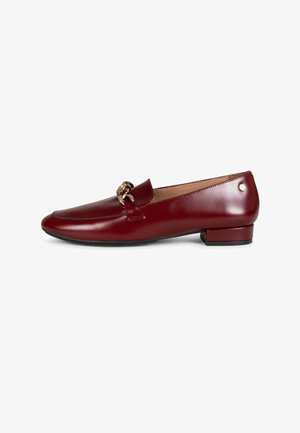 Mocasín de cuero rojo oscuro para mujer con tacón bajo de bloque y detalle de cadena en tono dorado en la parte superior, vista lateral sobre fondo blanco.