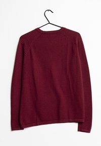 Burgundy-neulepaita, jossa on ribbikuvio, pyöreä pääntie ja pitkät hihat, esillä riippumassa mustalla koukulla.