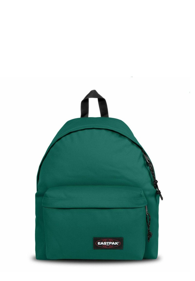 Mochila de tela verde con forma redondeada, que presenta un bolsillo con cremallera en la parte frontal y un parche de logo negro. Incluye un asa en la parte superior y correas clásicas.