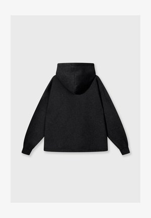 Sudadera con capucha negra de corte relajado, hecha de una tela suave, con una gran capucha en la parte posterior y mangas largas. Sin logotipos ni patrones visibles.