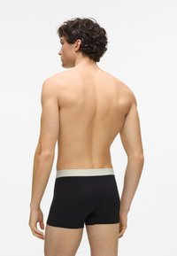 Boxeri negri cu talie elastică gri deschis, confecționați din material neted, vedere din spate cu un design slim fit.