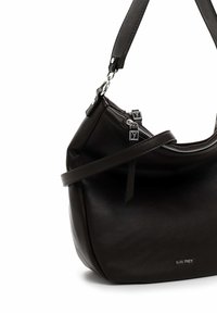 Sac à main en cuir marron foncé avec une bandoulière réglable, fermeture éclair en métal argenté et une texture lisse. Présente un branding subtil sur le côté.