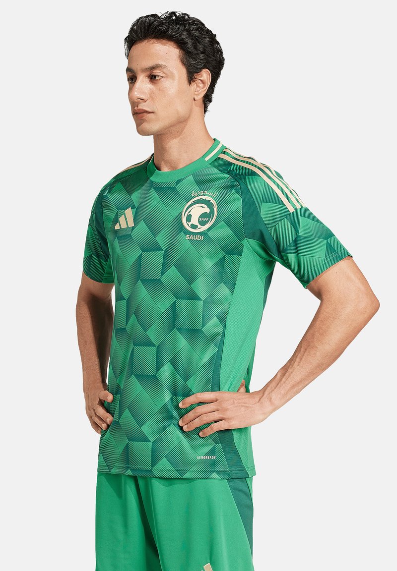 Maglietta da calcio verde con motivo geometrico, maniche corte e scollo tondo, con dettagli dorati e logo. Abbinata a pantaloni corti coordinati.