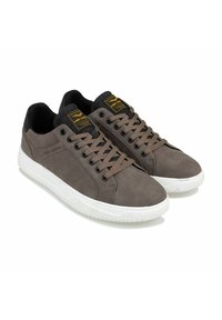 Grau Wildleder Sneakers mit schwarzen Akzenten, weißer Gummisohle, runder Zehenform und Schnürdesign. Mit einem gelben Logo auf der Zunge.