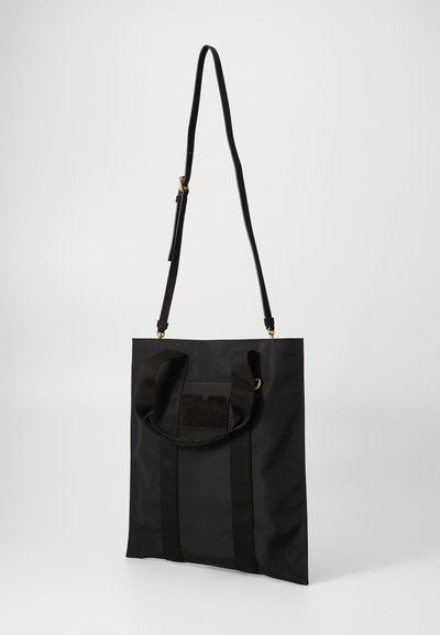 Geantă tote din material textil negru, cu două mânere superioare, curea pentru umăr ajustabilă și o textură netedă. Dispune de un buzunar frontal cu clapetă.