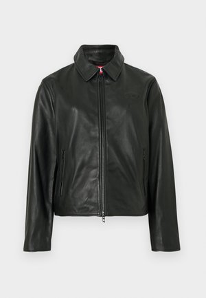 Chaqueta de cuero negra con cuello clásico, cremallera frontal y dos bolsillos laterales. Presenta un logo sutilmente grabado en el pecho. Textura suave.