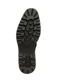 Suela de goma negra con un patrón de agarre texturizado, que presenta formas de cruz y estrella para mejorar la tracción. Marcada con "Wittchen handmade" en el centro.