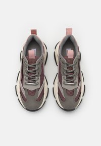 Sportschuhe, die aus einer Kombination von grauem Mesh und weinrotem synthetischen Material bestehen, mit einer cremefarbenen Sohle und schwarzen Gummielementen.