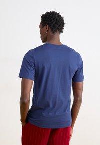 Σκούρο μπλε κοντομάνικο μπλουζάκι φτιαγμένο από βαμβάκι, με κλασικό λαιμό crew και άνετη γραμμή. Ξεχωριστή υφή, ελάχιστες λεπτομέρειες.