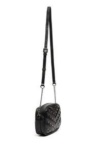 Černá crossbody taška z umělé kůže s prošívaným designem, stříbrnými hroty a odnímatelným řetízkem pro nastavení délky.