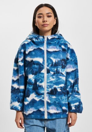 Blaues Fleece-Hoodie mit einem Berglandschaftsmuster in verschiedenen Blautönen und Weiß. Mit durchgehendem Reißverschluss und Kapuze.