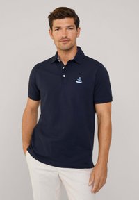Polo shirt blu navy con colletto, patta con tre bottoni e logo ricamato. Tessuto di cotone morbido con maniche corte e vestibilità classica.