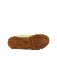 Suola di scarpa sportiva verde con superficie in gomma texture, caratterizzata da un motivo a spina di pesce e un logo centrale.