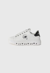 Sneaker bianchi con punta rotonda, suole bianche texturizzate, con un tacco a cappuccio nero glitterato e un personaggio stampato che indossa occhiali da sole.