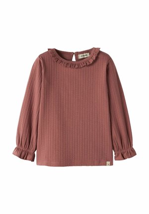 Haut côtelé rose poudré à manches longues avec encolure et poignets à volants, petite fermeture par bouton au dos et étiquette en tissu près de l’ourlet.