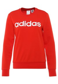 Felpa rossa realizzata in misto cotone, con collo a giro e maniche lunghe. Logo "adidas" in grandi lettere bianche sul petto.