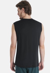 Svart ärmlös T-shirt i mjukt tyg, med rundad hals och rak passform, har en jämn textur och inga synliga logotyper.