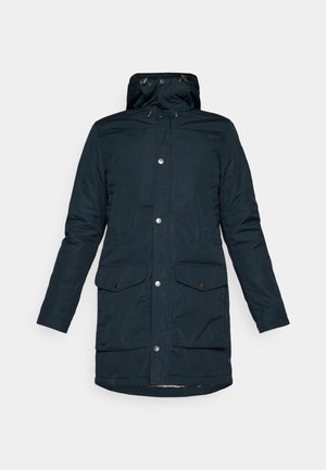 Navy blue parka jacket with a hood, featuring snap button closures, two front pockets, and a slightly longer back hem.