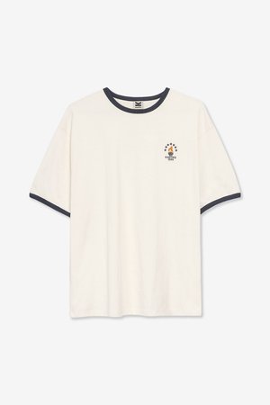 Crèmekleurig katoenen T-shirt met een marineblauwe geribbelde kraag en mouwranden. Voorzien van een kleine afgedrukte afbeelding met een zeilboot en sterren op de borst.