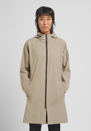 Beige regenjas met een capuchon, voorzien van een veilige rits aan de voorkant, zijzakken en een ontspannen pasvorm. Glad materiaal, knielange ontwerp en minimale accenten.