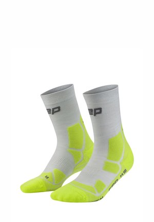 Pair of gray and neon yellow athletic socks with cushioned areas and brand logo on ankles and soles.