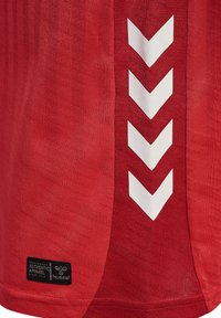 Maglietta sportiva rossa con tessuto testurizzato, motivo a chevron bianco e etichetta nera con logo sull'orlo.