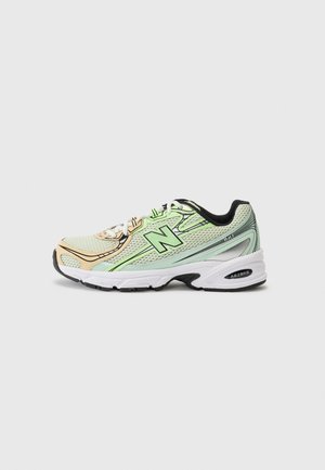 Baskets de sport vert clair et beige avec un matériau en maille, des accents noirs et une semelle blanche. Les caractéristiques incluent des lacets et un logo "N" bien visible.