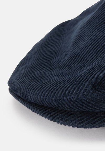 Námornícky modrá kordurová čiapka s textúrovaným povrchom, ktorá má jemné ryhované vzory a zaoblený okraj so šitým lemom.