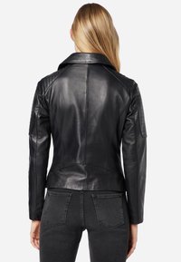 Schwarze Leder-Motorradjacke mit gesteppten Schulterakzenten und taillierter Passform. Verfügt über einen breiten Kragen und eine glatte Textur.