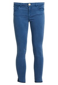 Blaue Skinny-Fit-Jeans mit Fronttaschen, Knopfverschluss, Gürtelschlaufen und Schlitzen an den Knöcheln auf weißem Hintergrund.