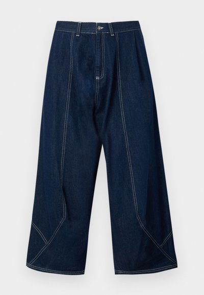 Denimbukser i mørkeblå med bred ben-design, der har kontrastsyninger og skrå søm-detaljer, hvilket giver et struktureret udseende.