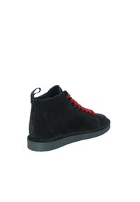 Sneaker alta in suede nero con lacci rossi, suola in gomma e una linguetta sul tallone per facilitarne l'indossamento. Dettagli cuciti sottili.