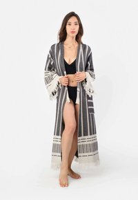 Ilgas pilkai baltos dryžuotos kimono su kutais kraštais, pagamintas iš tekstūrinio audinio, atviras priekyje ir su šoninėmis skeltuvėmis, kad būtų patogu judėti.