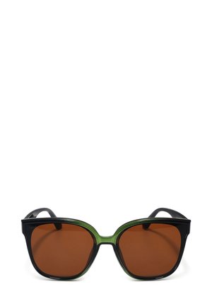 Černé a zelené sluneční brýle ve tvaru motýla, hnědé sklo, silné rámy a lesklý povrch. Akcenty zdůrazňují designové prvky.