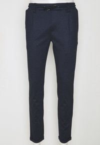 Pantalon bleu marine ajusté avec ceinture élastique et cordon noir, avec poches latérales et ourlets revers.