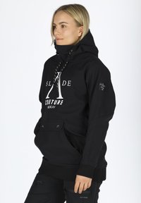 Felpa nera con collo alto, cappuccio con coulisse, tasca frontale e stampa del logo bianco. Presenta polsini e orlo a costine per una vestibilità aderente.