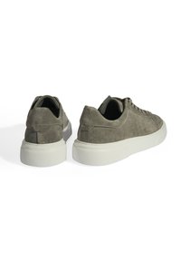 Graue Wildleder-Sneaker mit einer weißen Gummisohle, ausgestattet mit einem Low-Top-Design und klassischen Schnürdetails. Gerundete Zehenpartie und minimale Nähte.