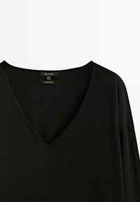 Zwarte V-hals top met lange mouwen, gemaakt van zachte stof. Heeft een eenvoudig ontwerp, een gladde textuur en een minimalistische stijl.