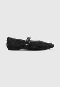 Black flat shoe with a rounded toe, textured surface featuring small studs, and a single adjustable strap across the instep.