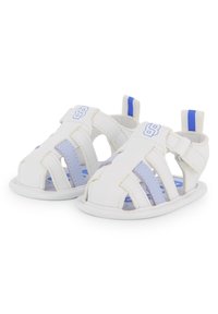 Sandalias de cuero blanco con diseño recortado, detalles en azul y correa ajustable; suela texturizada con amortiguación para mayor comodidad.