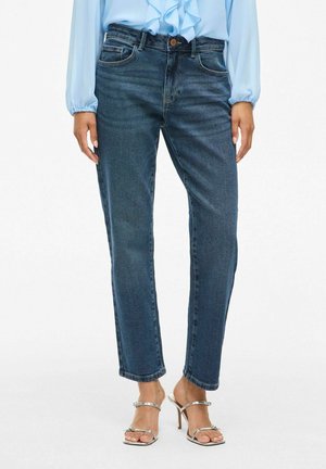 Jeans en denim bleu foncé avec une coupe droite, cinq poches et une fermeture à bouton en métal. Présente une finition propre et texturée.