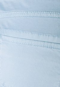Light blue fabric with a smooth texture featuring horizontal stitched lines. The material appears soft and lightweight.