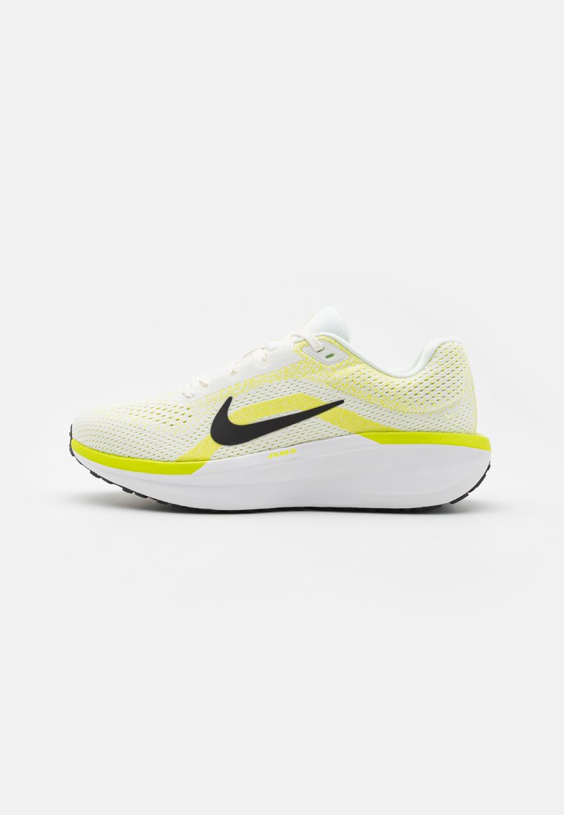 Buty biegowe Nike mają białą siatkową cholewkę z żółtymi akcentami, czarną swooshem i wyściełaną podeszwą dla wsparcia i komfortu.