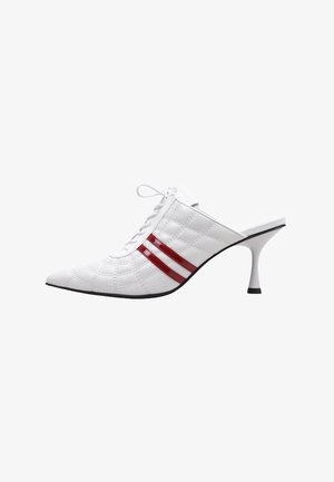 Tacón mule blanco acolchado con punta puntiaguda, parte delantera con cordones y dos rayas rojas brillantes en el lateral, con un delgado tacón de aguja curvado.
