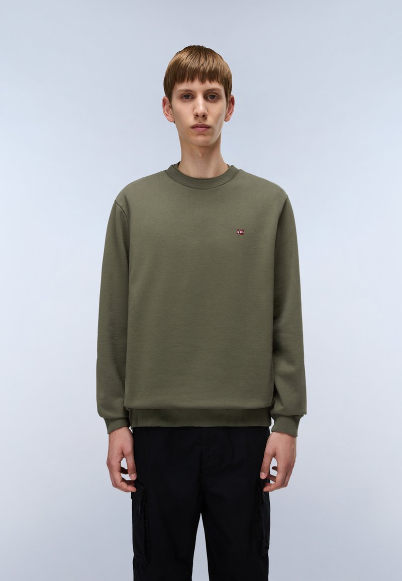 Sudadera verde oliva con cuello redondo, mangas largas, puños y dobladillo acanalados. Presenta un pequeño emblema bordado en el pecho.