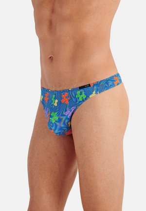 Male torso wearing blue swim briefs with a multicolored abstract floral pattern against a plain white background.